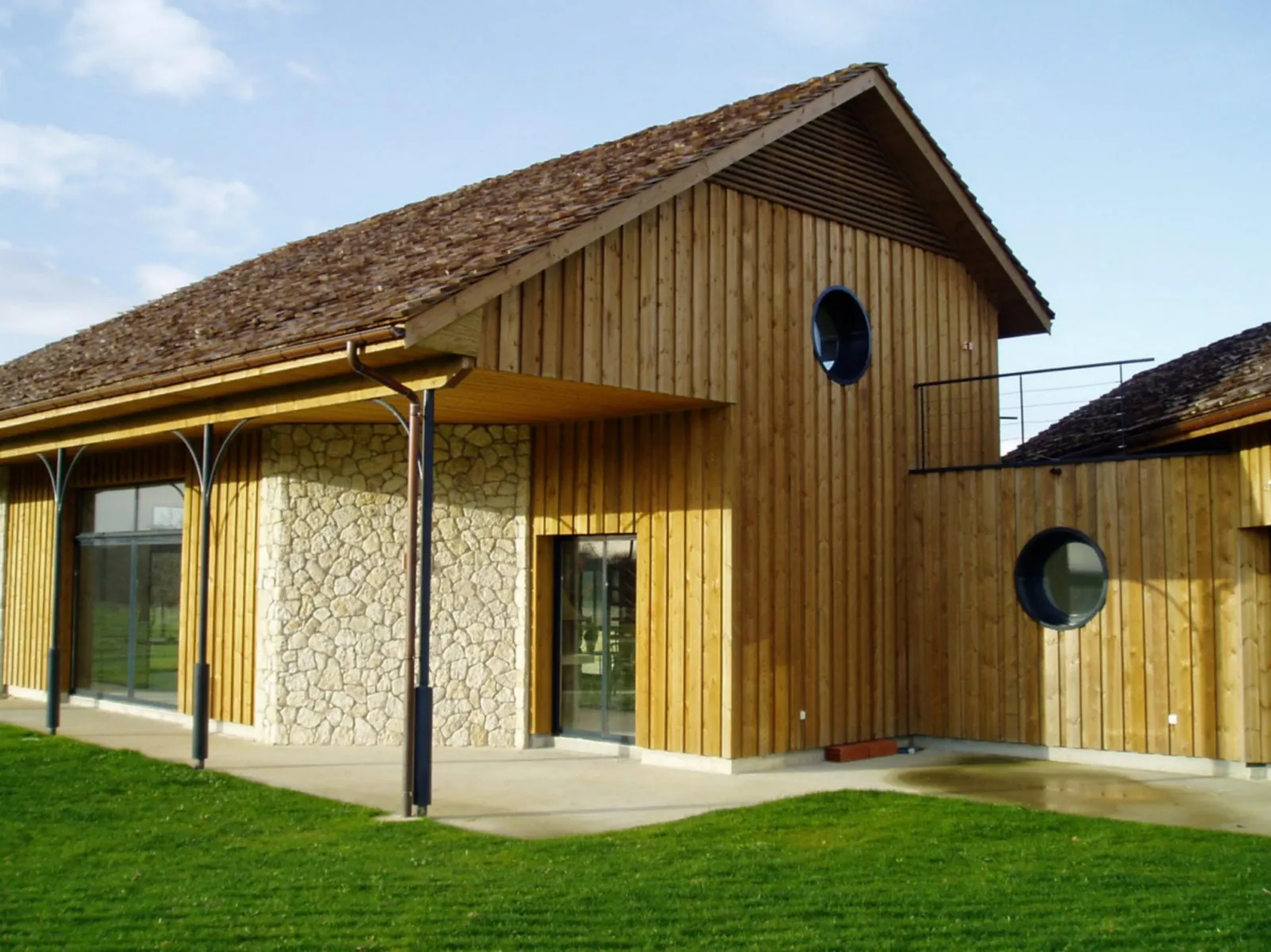 Maison à ossature bois avec bardage brut de sciage et toiture en bardeaux de pin des Landes, réalisée par Brisse Les Charpentiers